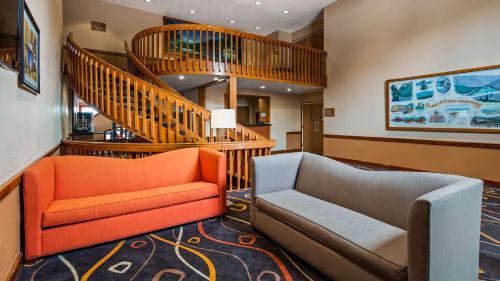 a living room with a couch and a staircase at Best Western White Mountain Inn in Franconia