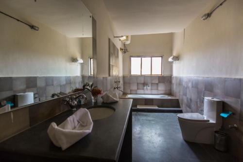 La grande salle de bains est pourvue d'un lavabo et de toilettes. dans l'établissement Maati Jungle Lodge Resort Bandhavgarh, à Tāla