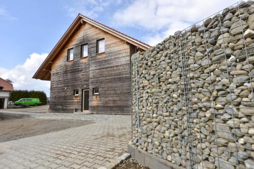 a stone wall next to a building with a barn at Gut Hügle Jugendzimmer in Ravensburg