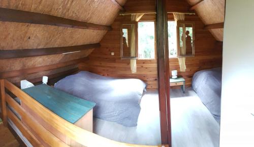 a small room with a bed in a wooden cabin at Chalet des plaines in La Plaine des Palmistes