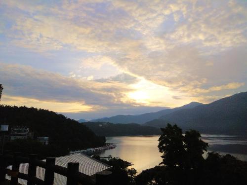 a view of a body of water with the sun setting at Sun Moon Lake Crown Yu Hotel in Yuchi
