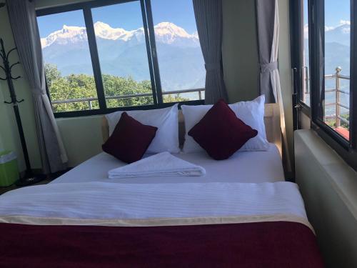 a bedroom with a bed with a view of mountains at Hotel Pristine Himalaya in Pokhara