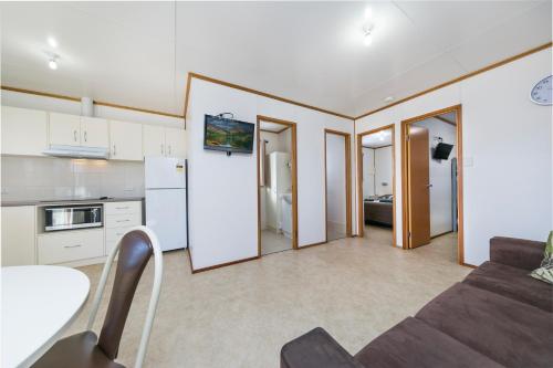 a kitchen and living room with white cabinets and a couch at Border Village Roadhouse in Border Village