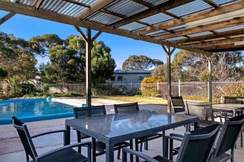 a patio with a table and chairs and a swimming pool at Border Village Roadhouse in Border Village