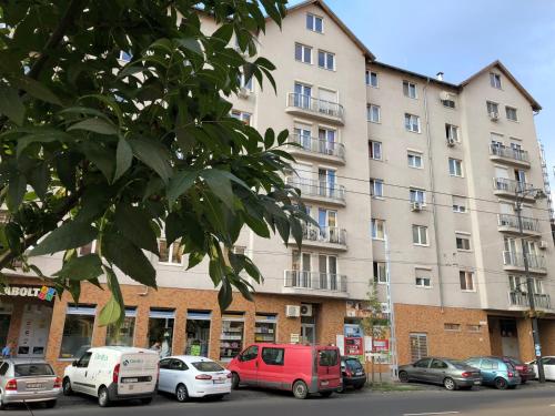 un grand bâtiment avec des voitures garées devant lui dans l'établissement Cozy Apartment in District 8, à Budapest