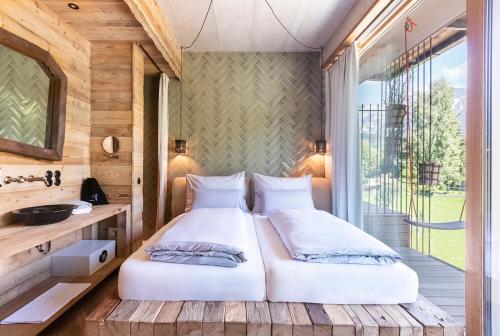 a bedroom with two beds and a balcony at HOTEL SEPP - Alpine Boutique Hotel - Adults Only in Maria Alm am Steinernen Meer