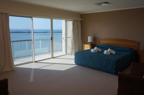 a bedroom with a bed and a dog on the bed at Moorings Beach Resort in Caloundra