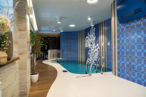 uma piscina num quarto com azulejos azuis em Kulibin Park Hotel & SPA em Níjni Novgorod