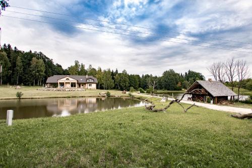 a house next to a lake with a building at Prūsiškių dvaras in Sumiliszki