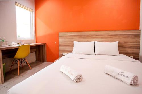 ein Schlafzimmer mit einem Bett mit zwei Handtüchern darauf in der Unterkunft LeGreen Suite Supomo in Jakarta