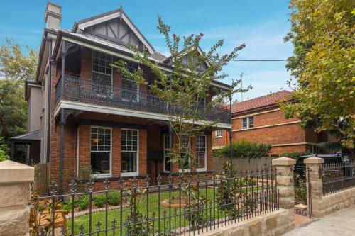 a brick house with a wrought iron fence at Dalziel Lodge in Sydney