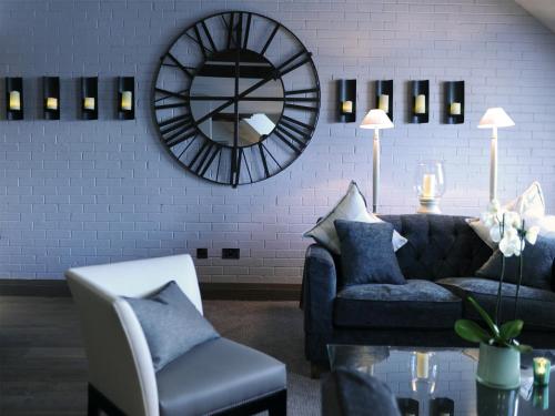 a living room with a couch and a chair and a mirror at Macdonald Windsor in Windsor