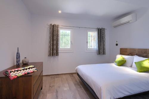 a bedroom with a large bed and two windows at Villa Anna in Begur