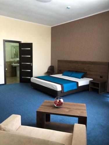 a bedroom with a bed and a couch and a table at Kechkemet Hotel in Simferopol
