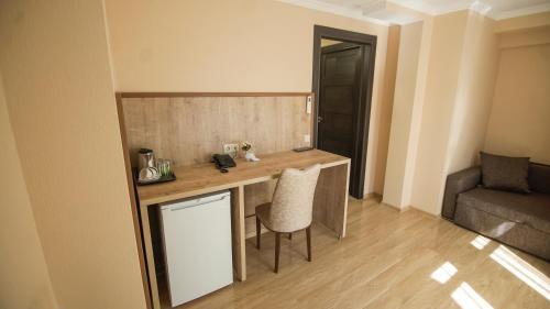 een kleine keuken met een bureau en stoelen in een kamer bij Hotel Juralius in Tbilisi City