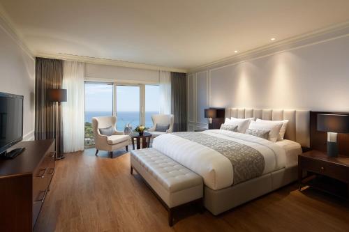 a hotel room with a bed and a television at Lotte Hotel Jeju in Seogwipo