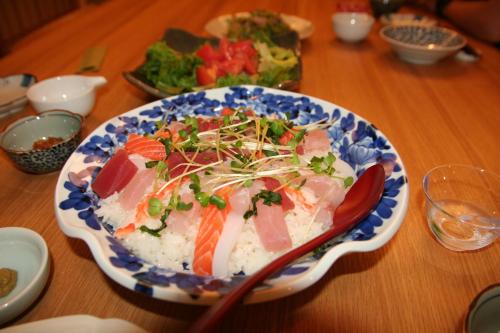 a blue and white plate of food on a wooden table at Yakunoyado Taguchi in Yakushima