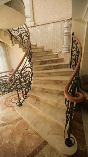 a staircase in a building with a wrought iron railing at Hotel Juralius in Tbilisi City