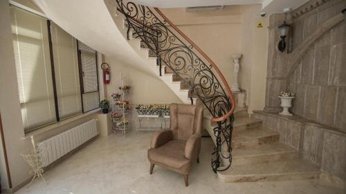 a stairway with a chair and a stair railing at Hotel Juralius in Tbilisi City