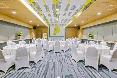 a conference room with white tables and white chairs at YELLO Hotel Paskal Bandung in Bandung
