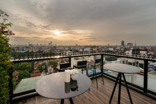 a balcony with a table and a view of a city at La Nueva Boutique Hotel Hanoi & Spa in Hanoi