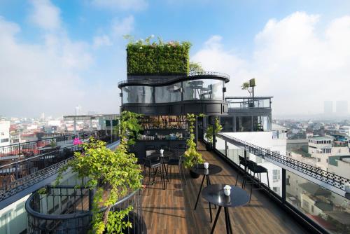a balcony with tables and plants on a building at La Nueva Boutique Hotel Hanoi & Spa in Hanoi