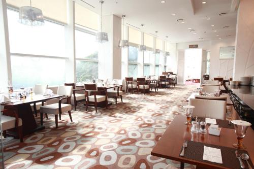 a restaurant with tables and chairs and large windows at Hotel Riviera Geoje in Geoje 