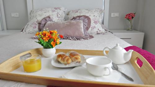 un vassoio con prodotti per la colazione e caffè su un letto di La Sastrería del Realejo a Cordoba