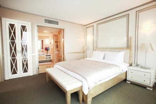 a bedroom with a large white bed and a window at Hotel Riviera Geoje in Geoje 