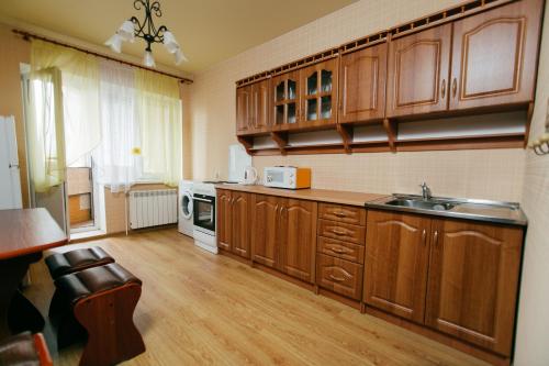 タンボフにあるApartment PrezentHaus Gorkogo 20の大きなキッチン(木製キャビネット、シンク付)