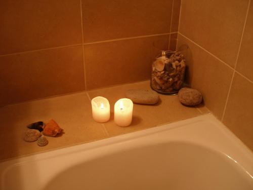 萊里達的住宿－Hotel Reina Isabel，两把蜡烛坐在浴缸的边缘