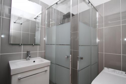 ein Bad mit einer Dusche, einem Waschbecken und einem WC in der Unterkunft COPACABANA - 3 pièces vue mer avec piscine et parking in Canet-en-Roussillon