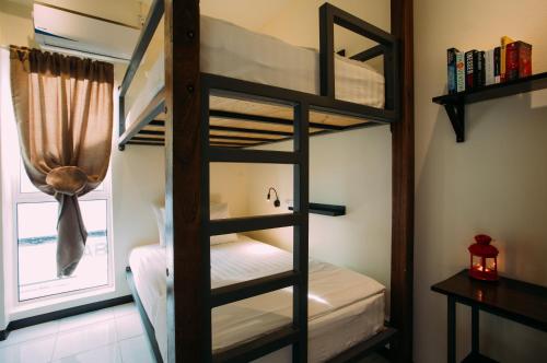 a bunk bed room with two bunk beds and a window at Kuree Hut in Semporna