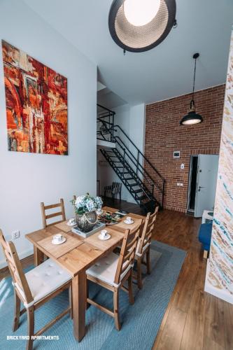 a dining room with a wooden table and chairs at Brickyard Apartments Cluj in Cluj-Napoca
