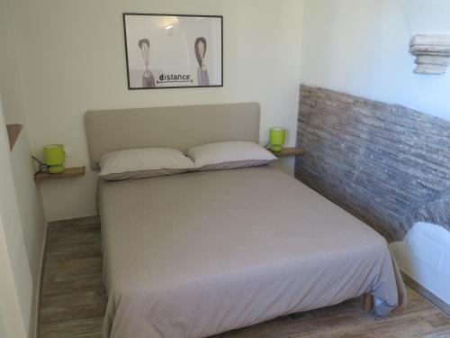 a bed in a room with two green candles on it at La Piccola Dimora in Tivoli