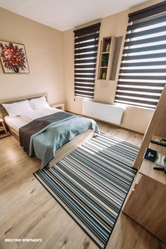 a bedroom with a bed and a large rug at Brickyard Apartments Cluj in Cluj-Napoca