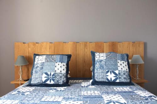 a bedroom with two beds with blue and white pillows at La Ferme du Cayla in Linac