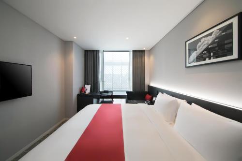 a hotel room with a red and white bed and a chair at Aiden by Best Western Cheongdam in Seoul