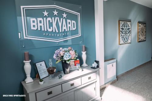 a sign on a wall with flowers on a dresser at Brickyard Apartments Cluj in Cluj-Napoca