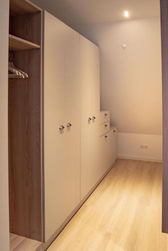 a room with white cabinets and a closet at Boardinghouse Sorgenfrei in Hagen
