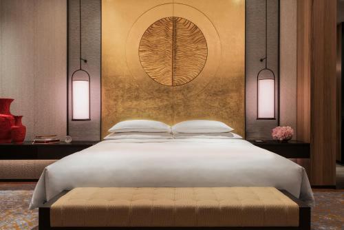 a bedroom with a large white bed with a wall at Grand Hyatt Changsha-Close to Helong Sports Center in Changsha
