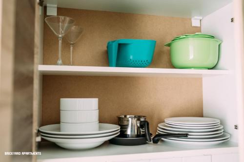a shelf filled with plates and bowls and dishes at Brickyard Apartments Cluj in Cluj-Napoca