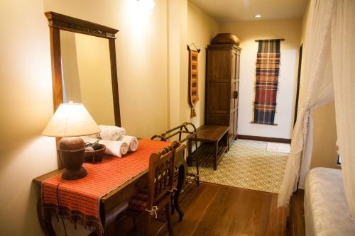 a bedroom with a bed and a table with a lamp at Baan Orapin in Chiang Mai