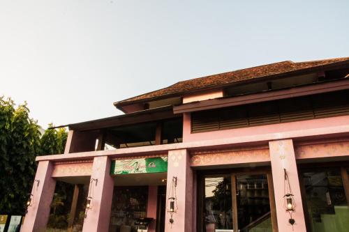 a pink building with a sign in front of it at Baan Orapin in Chiang Mai