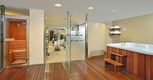 a bathroom with a shower, sink, and tub at Hotel CMC Girona in Girona