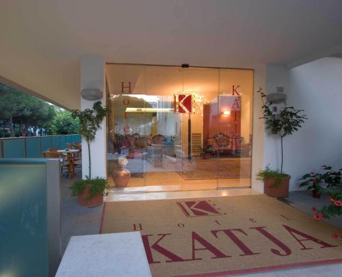a room with a large glass door with a table at Hotel Katja in Bibione