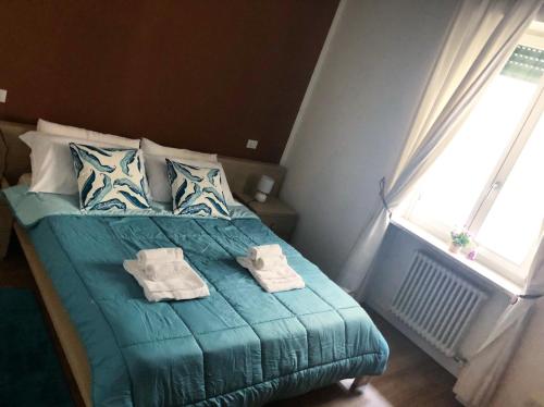 una camera da letto con un letto verde e asciugamani di Leoncino Apartment 2 a Verona