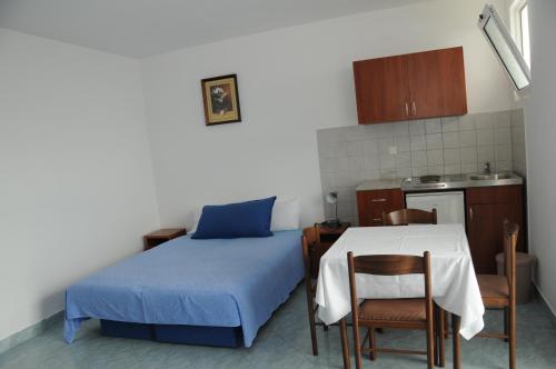 a room with a bed and a table and a kitchen at Apartments Dragišić in Sveti Stefan