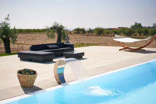 a pool with a couch and a hammock next to at Oliveira House in Castelo Novo