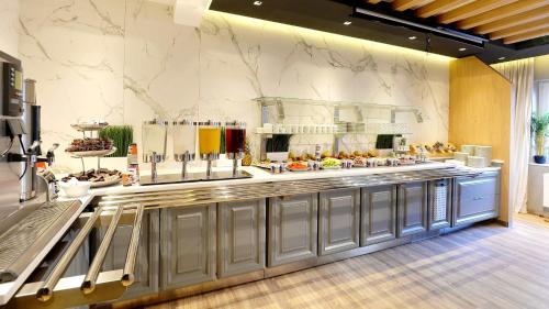 a kitchen with a counter with food on it at St.Joseph Hotel Hamburg - Reeperbahn St.Pauli Kiez in Hamburg